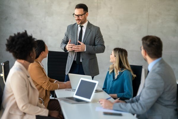 A man speaking to others in a meeting